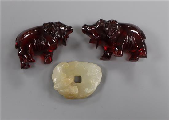 A Chinese pale celadon jade bat bi disc and two cherry amber elephants